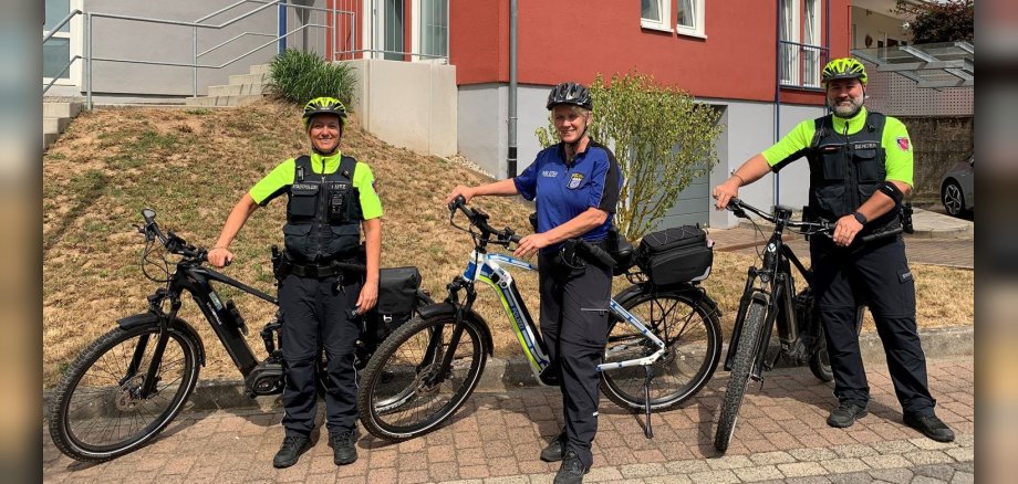 Zwei Polizistinnen und ein Polizist mit E-Bikes