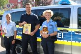 Leon-Hilfe-Inseln Schutzfrauen und -mann vor Ort mit Aufkleber der Leon-Hilfe-Inseln in der Hand