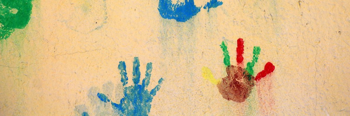 Farb-Hände auf gelber Wand