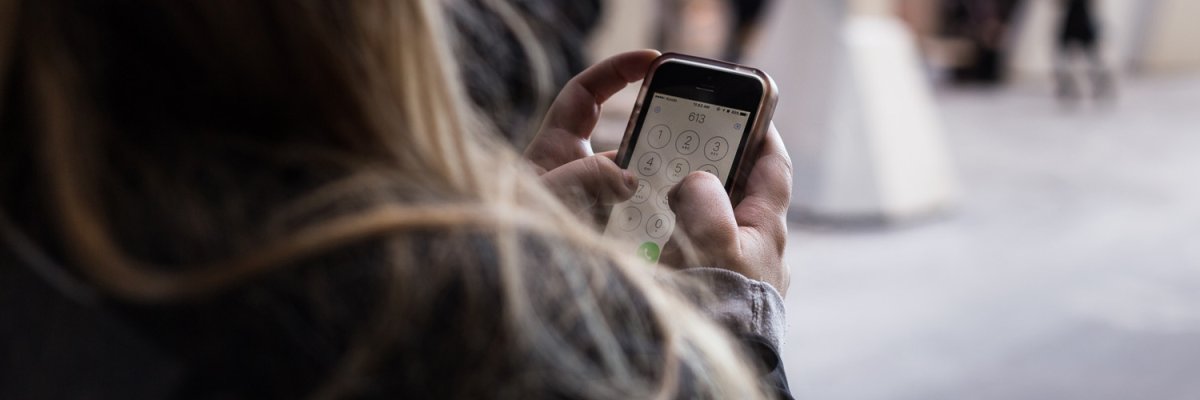 Nummer in Handy eintippen Frau tippt Nummer in Handy ein