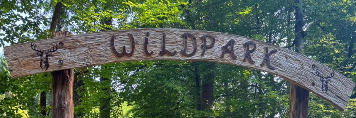Begrüßungsschild aus Holz über Eingang zum Wildpark Brudergrund