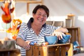 Altes Handwerk und mehr Frau in Stand mit Töpferware