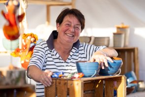 Altes Handwerk und mehr Frau in Stand mit Töpferware