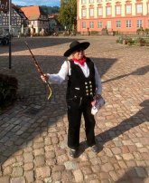 Auf der Walz Frau in Walz-Zunftkleidung mit Wanderstock