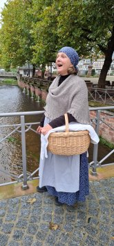 Wenn die Waschfrau plaudert Frau in historischem Kostüm einer Waschfrau und Personen die Waschkorb tragen